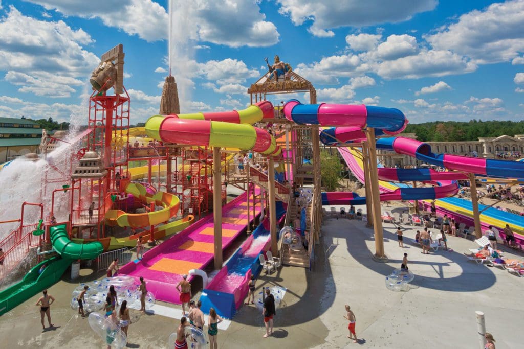 Mt. Olympus Water & Theme Park, one of the best places to visit in Wisconsin for families, featuring huge colorful waterslides and people walking around.