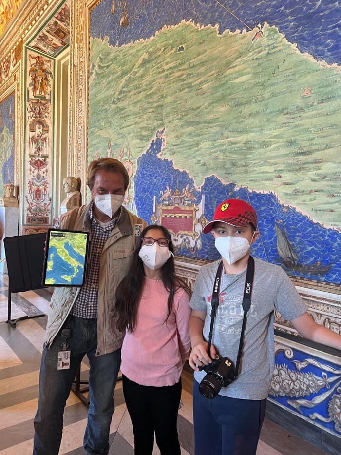 Two kids stand with their private guide, while touring the Vatican, a must stop on our Rome itinerary with kids.