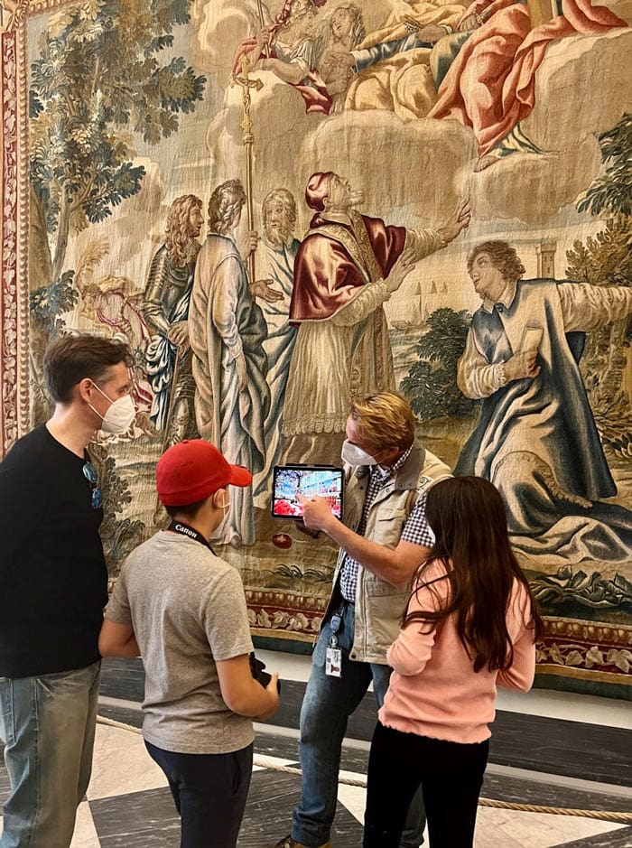 A dad and his two kids listen to a tour guide, while on a private tour in the Vatican Museum.