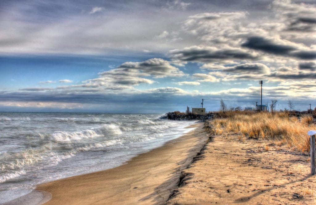 Shores of Lake Michigan at Illinois Beach State Park, with a sandy shoreline and clouds in the skies.