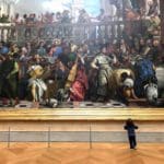 A kid at The Louvre infront of a large painting