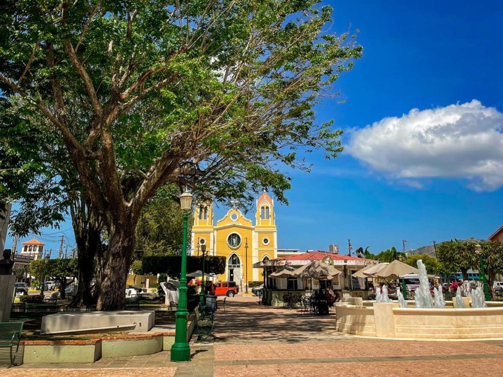 The town square in Añasco, with a large yellow church on one end in the distance.