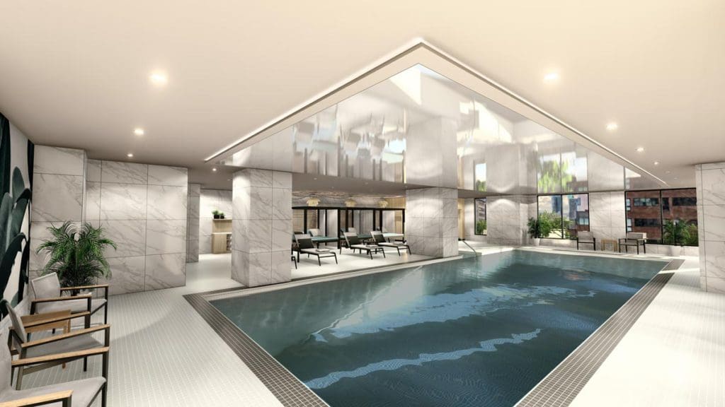 The chic indoor pool with surrounding pool deck at Hyatt Place Montréal – Downtown.