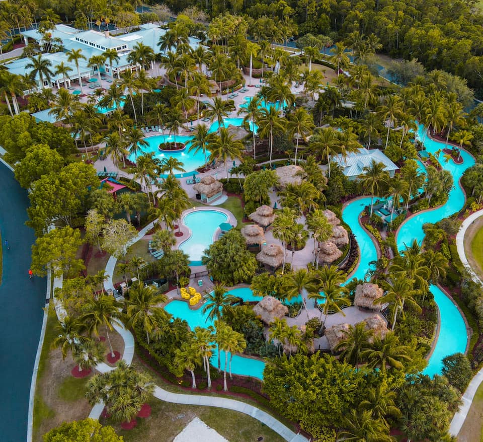 An aerial view of the large water area at Hyatt Residence Club Bonita Springs, Coconut Plantation, featuring a lazy river and water slide.