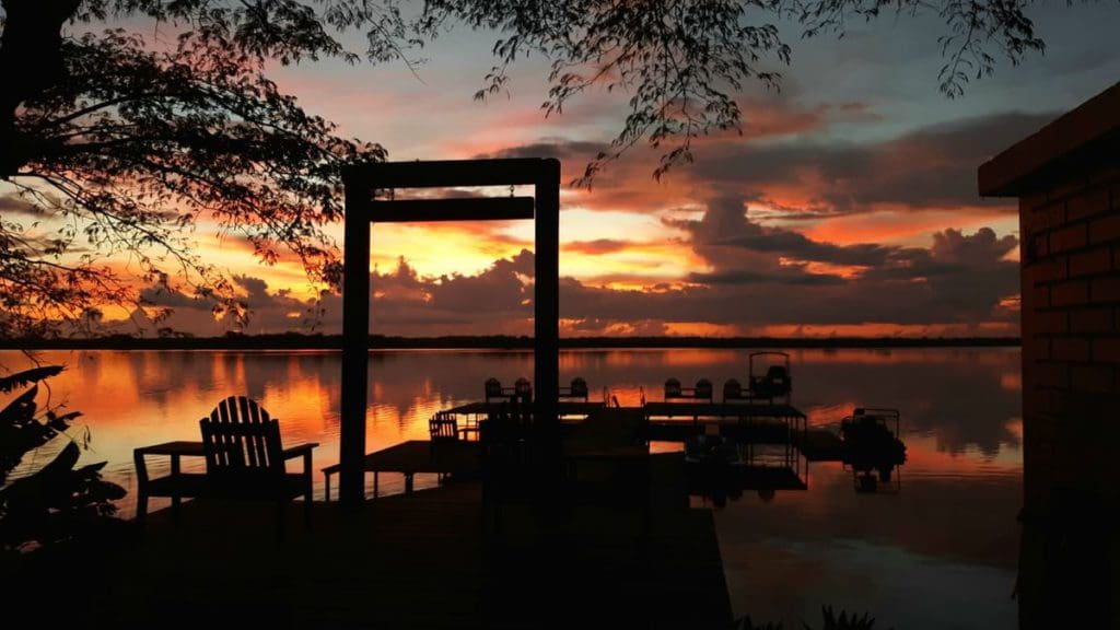 The dock and surrounding chairs at Lamanai Outpost Lodge at sunset.
