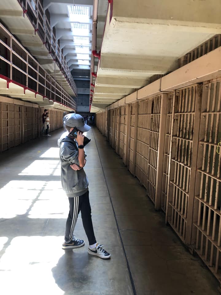 A young boy listens to an audio tour while exploring Alcatraz.