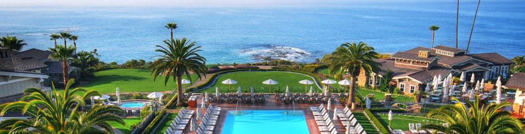 An aerial view of the outdoor pool with the Pacific Ocean as its backdrop at at Montage Laguna Beach, one of the best luxury hotels in the U.S for families.