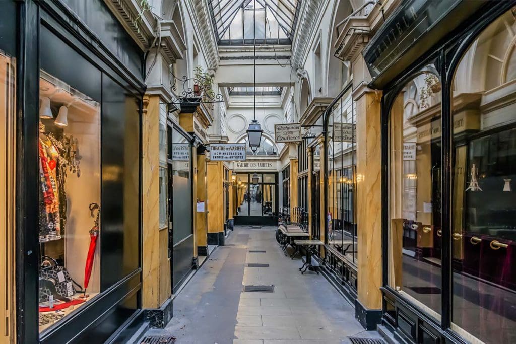 Inside the halls of the Passage des Panoramas, featuring cases and doors opening to antique Parisian shops.