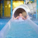 A young girl shoots out the exit of a waterslide at Reunion Resort & Golf Club.