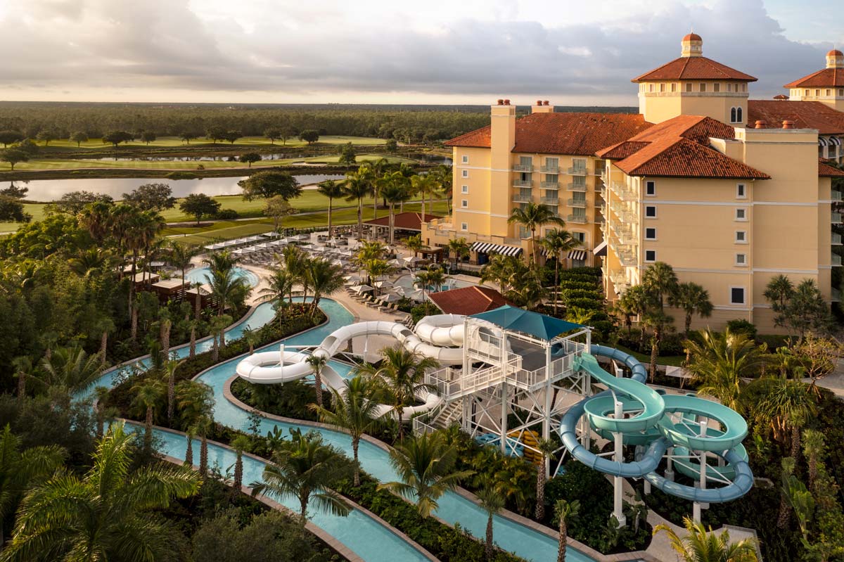 An aerial view of the three water slides near the resort buildings at The Ritz-Carlton Golf Resort, Naples at sunset, one of the best Florida hotels with water parks on the Gulf Coast for families.