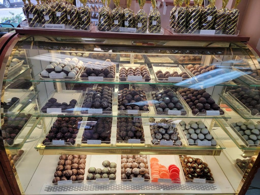 Rows of sweets in a dessert case at Thomas Sweets, including fudge and other small chocolates.
