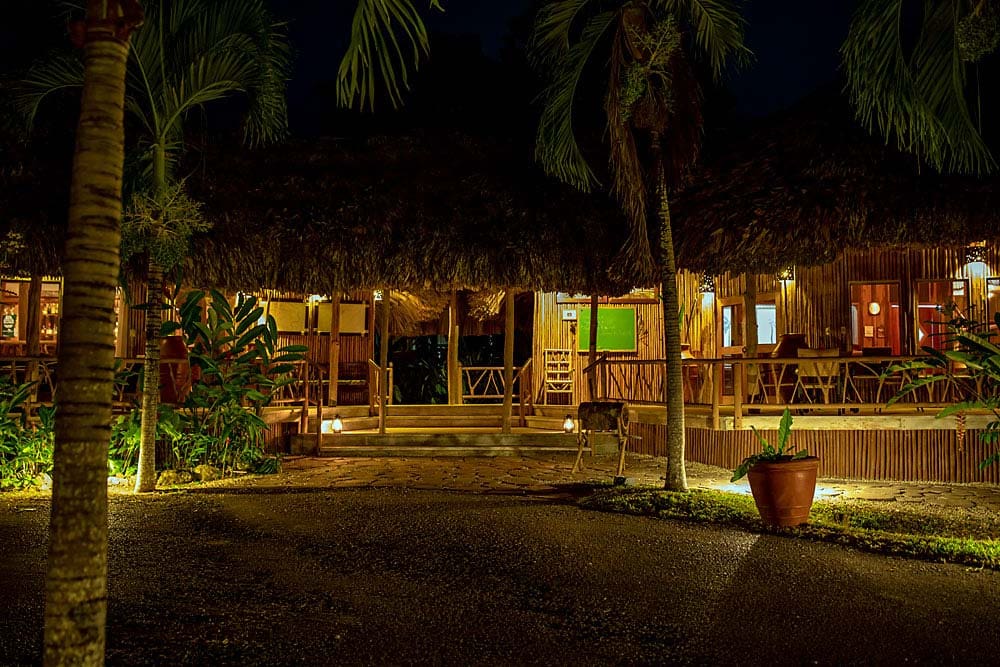 The exterior entrance to the bar area at Chan Chich Lodge at night.