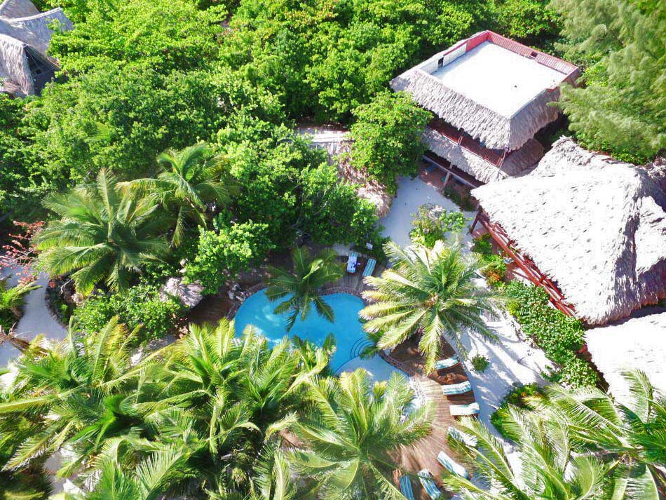 An aerial view of resort buildings, pool, and lush foliage of Xanadu Island Resort.