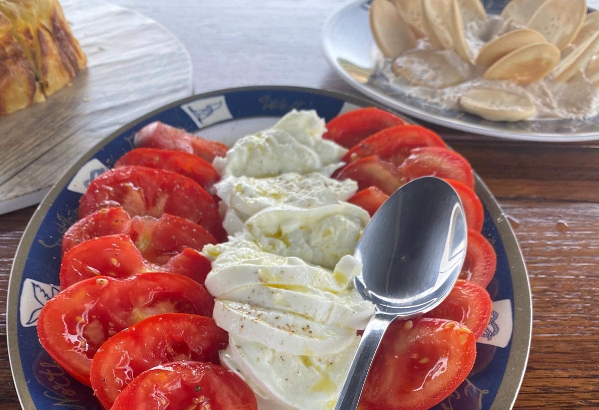 A plate of food, featuring fresh cheese and tomatoes, in Malta.
