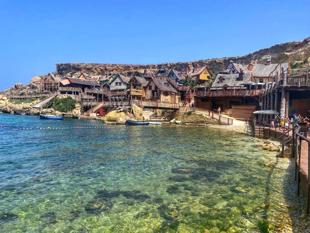 Popeye Village rests along the edge of a cliff near the sea in Malta - visiting this fun city is this is one of our best tips for visiting Malta with kids.
