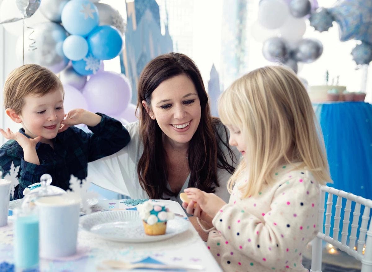 A mom and her two kids enjoy blue and white cupcakes while dining on-site at Shangri La at the Shard, one of the best London Hotels for Families.