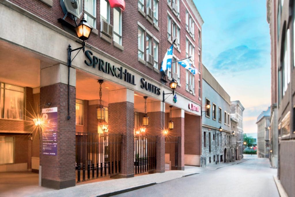 The lit-up entrance to SpringHill Suites by Marriott Old Montreal at dusk.