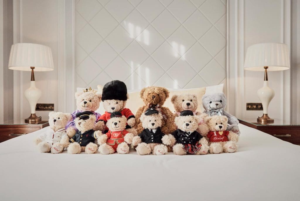 Several stuffed animals sit atop a freshly made bed at the London Marriott Hotel Park.