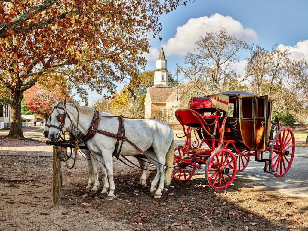 A horse-drawn carriage stands empty in a fall scene in Williamsburg, Virginia, one of the best Thanksgiving destinations in the United States for families.