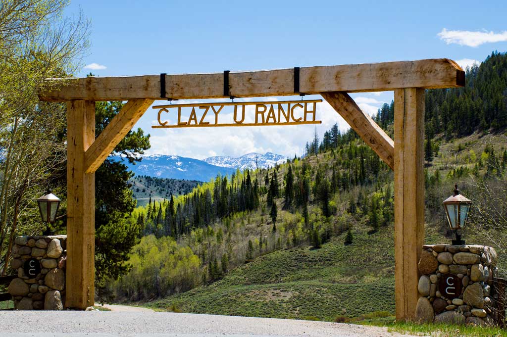 The entrance gate, reading C Lazy U Ranch in wrought iron above the drive.