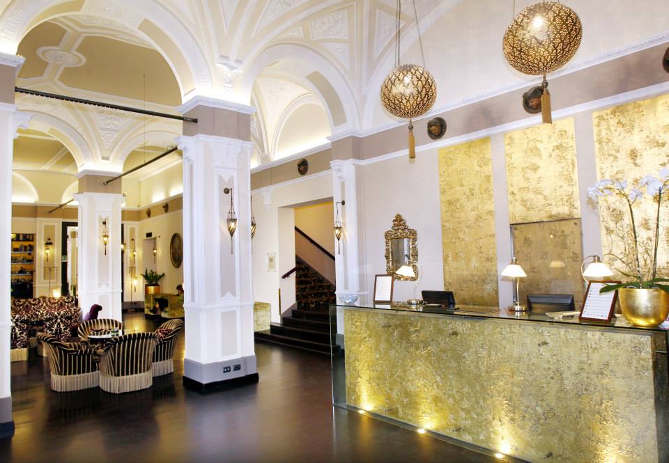 Inside the grand, gold-hued lobby of Hotel Bernini Palace.
