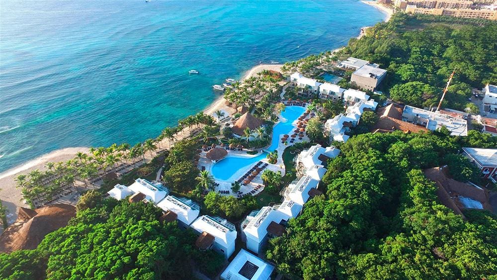 An aerial view of Sandos Caracol Eco Resort, nestled alongside the ocean in Mexico, one of the best resorts in Mexico with a water park for families.