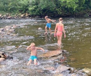 Kids play together in the water along the river below Minnehaha Falls in Minnesota.
